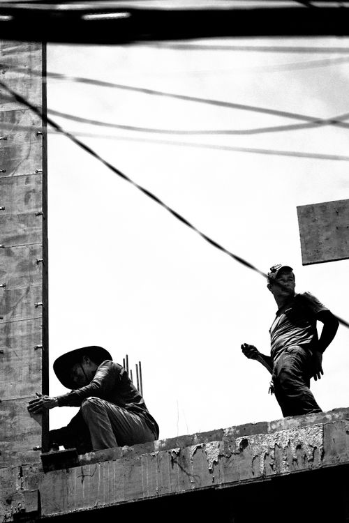 Free Black and white image of construction workers on a building site in Vietnam. Stock Photo