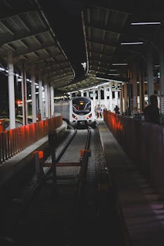 A modern train arrives at an illuminated platform in Istanbul at night.