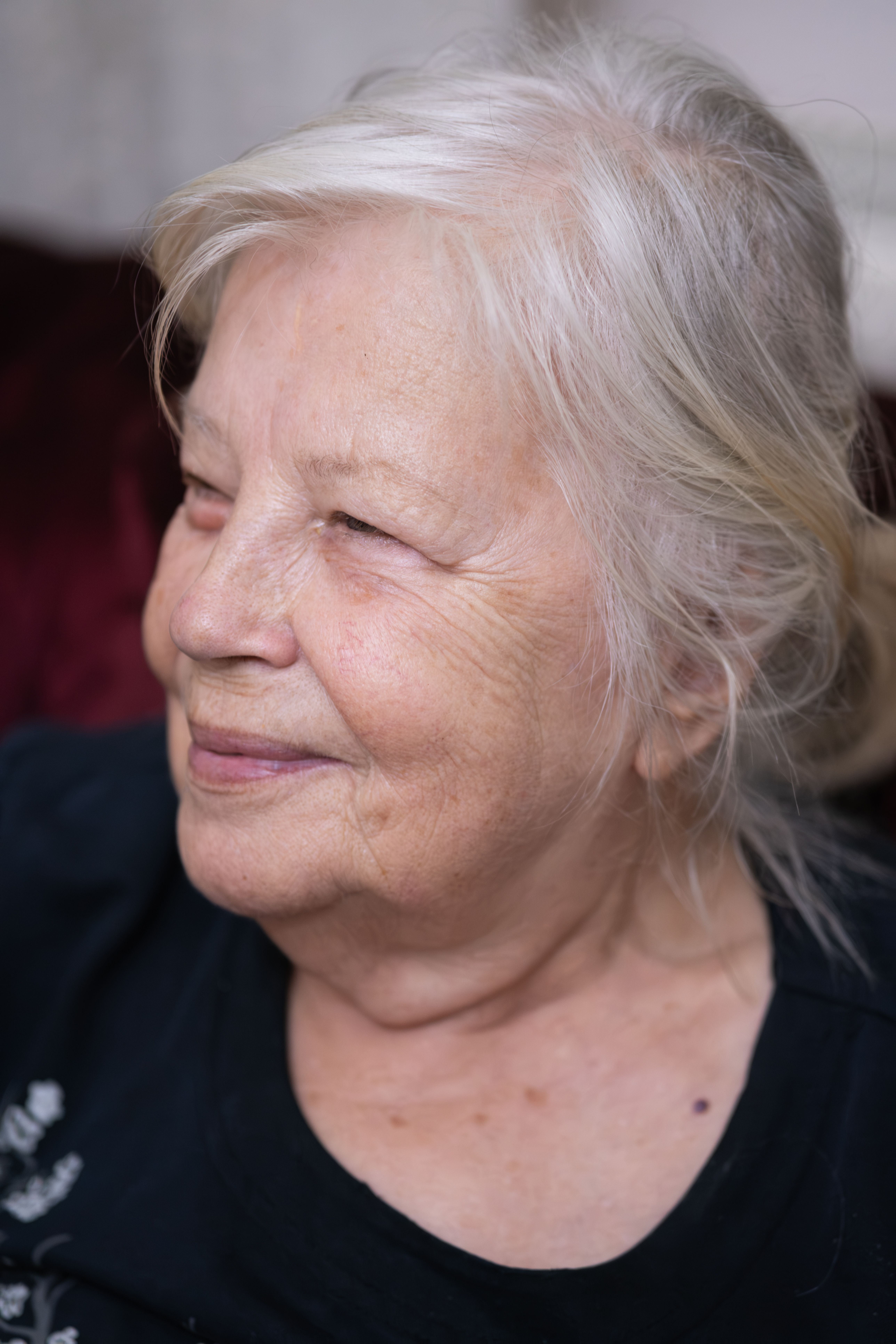 Portrait of a smiling senior woman indoors, captured in İzmir, Türkiye.