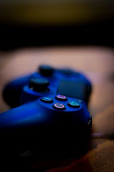 A dark, moody close-up of a game controller with glowing buttons.