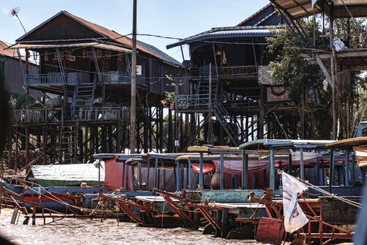 Rustic stilt houses and boats in the waters of Kampong Phluk, Cambodia.