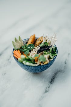 A vibrant bowl of Asian cuisine featuring fresh vegetables and sesame seeds.