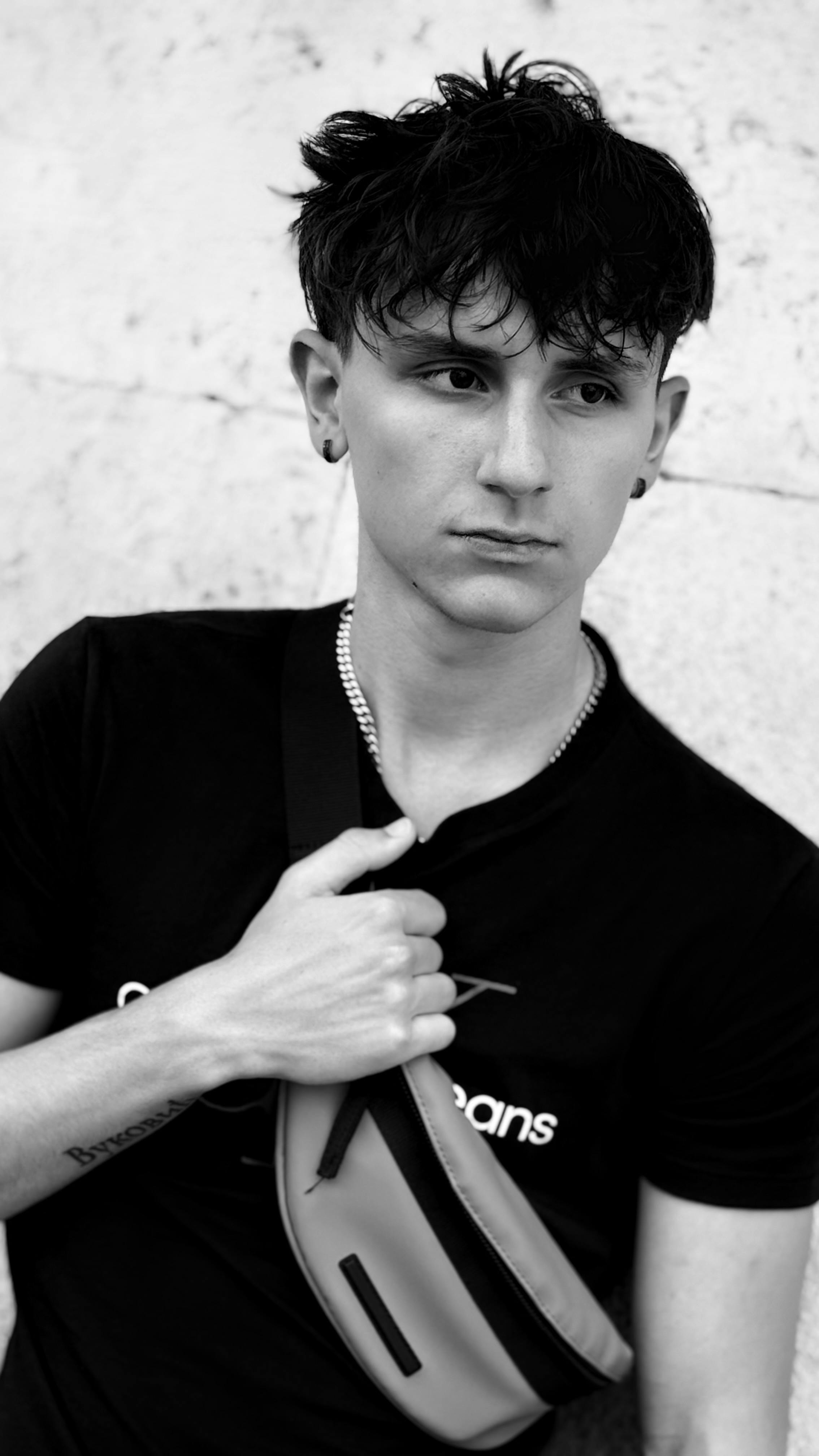 Black and white portrait of a stylish young man looking thoughtful.