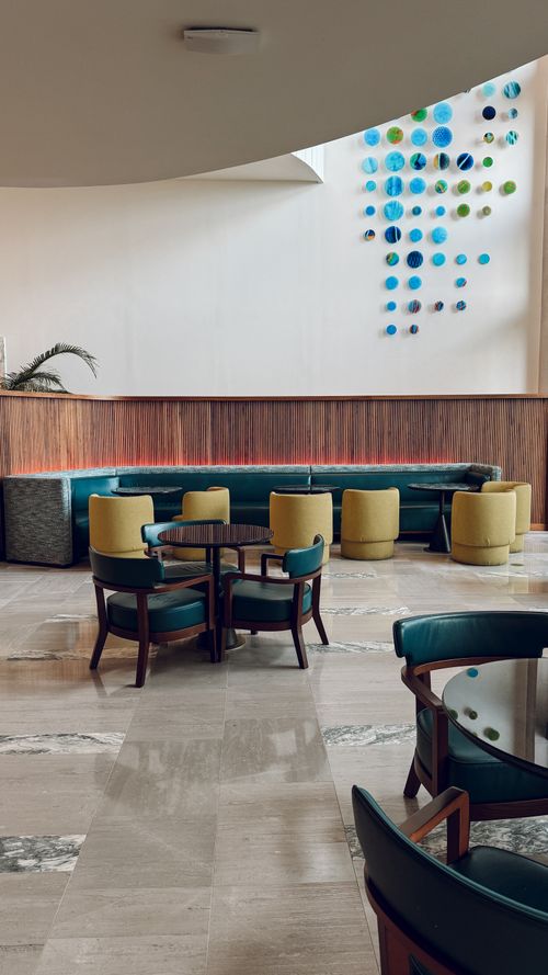 Free Elegant indoor lounge area with modern seating and artistic wall decor. Stock Photo