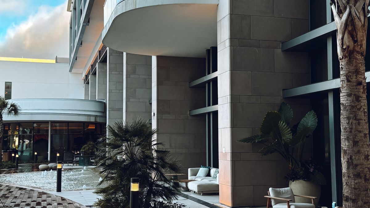 Outdoor terrace of a luxury hotel with sun loungers beside a clear swimming pool
