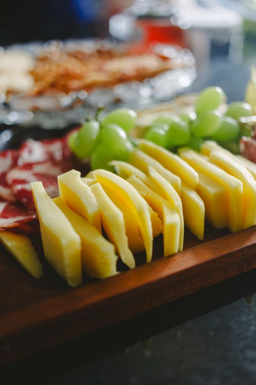 Free Close-up of a gourmet cheese platter featuring grapes, meats, and artisanal cheeses. Stock Photo