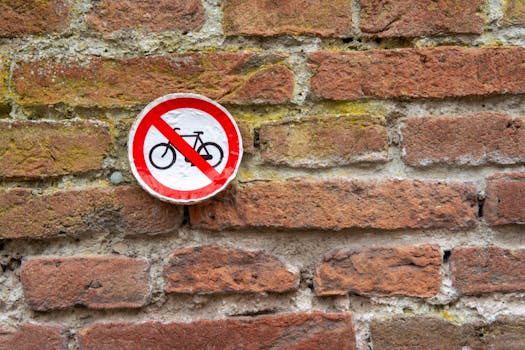 A 'No Bicycles' sign on a textured brick wall offering urban texture and restrictions.