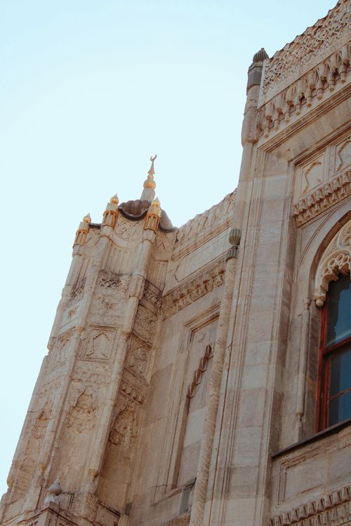 Free Detailed view of historic Gothic-style architecture with ornate carvings and clear sky background. Stock Photo