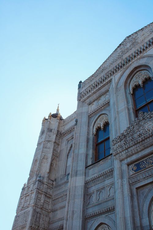 Free Intricate stone carvings on a historical mosque against a clear blue sky. Stock Photo
