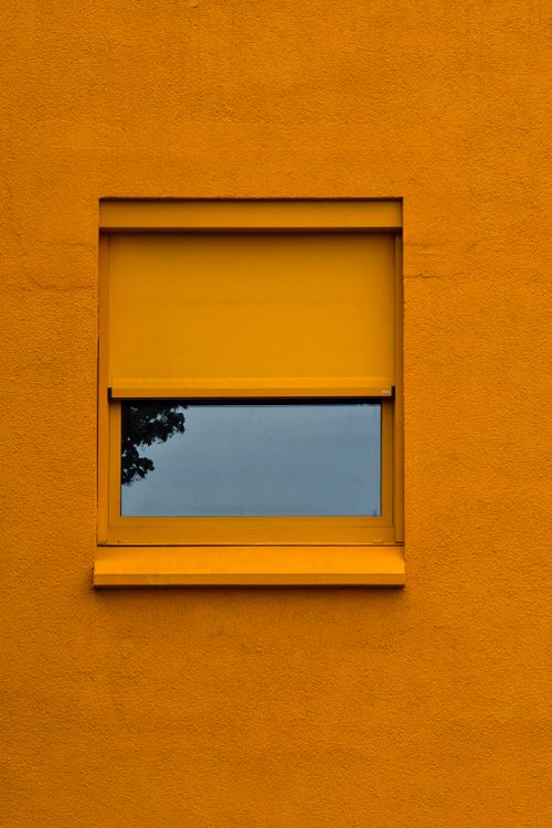 Free A vibrant yellow window with a reflective glass pane on a modern building facade in Berlin, Germany. Stock Photo