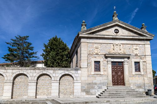 Free Charming stone chapel with archways in Ávila, Spain, under a vibrant blue sky. Stock Photo