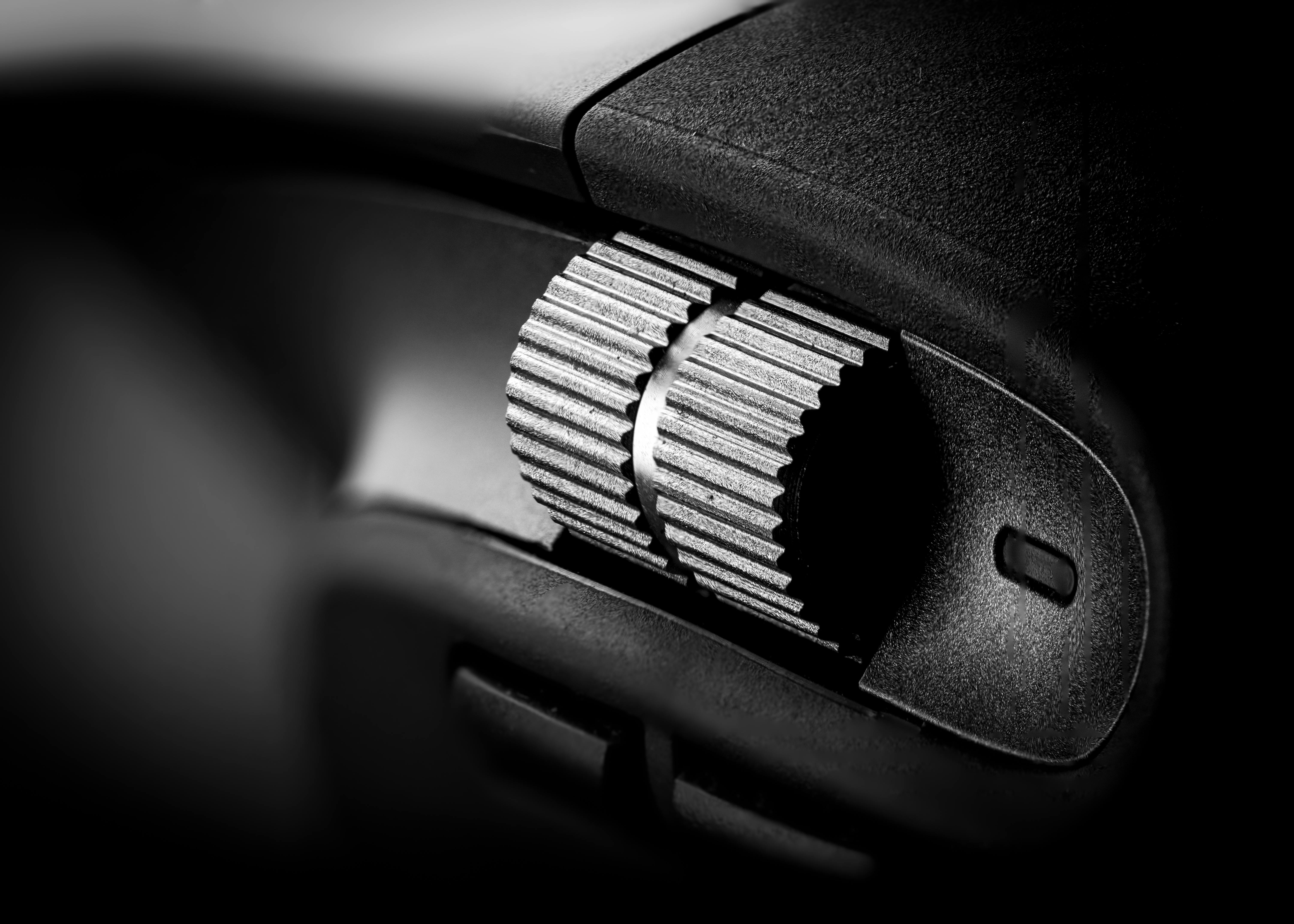 gratis Zwart-wit macro-opname van een getextureerde wijzerplaat op een gadget, waarbij het industriële ontwerp centraal staat. Stockfoto