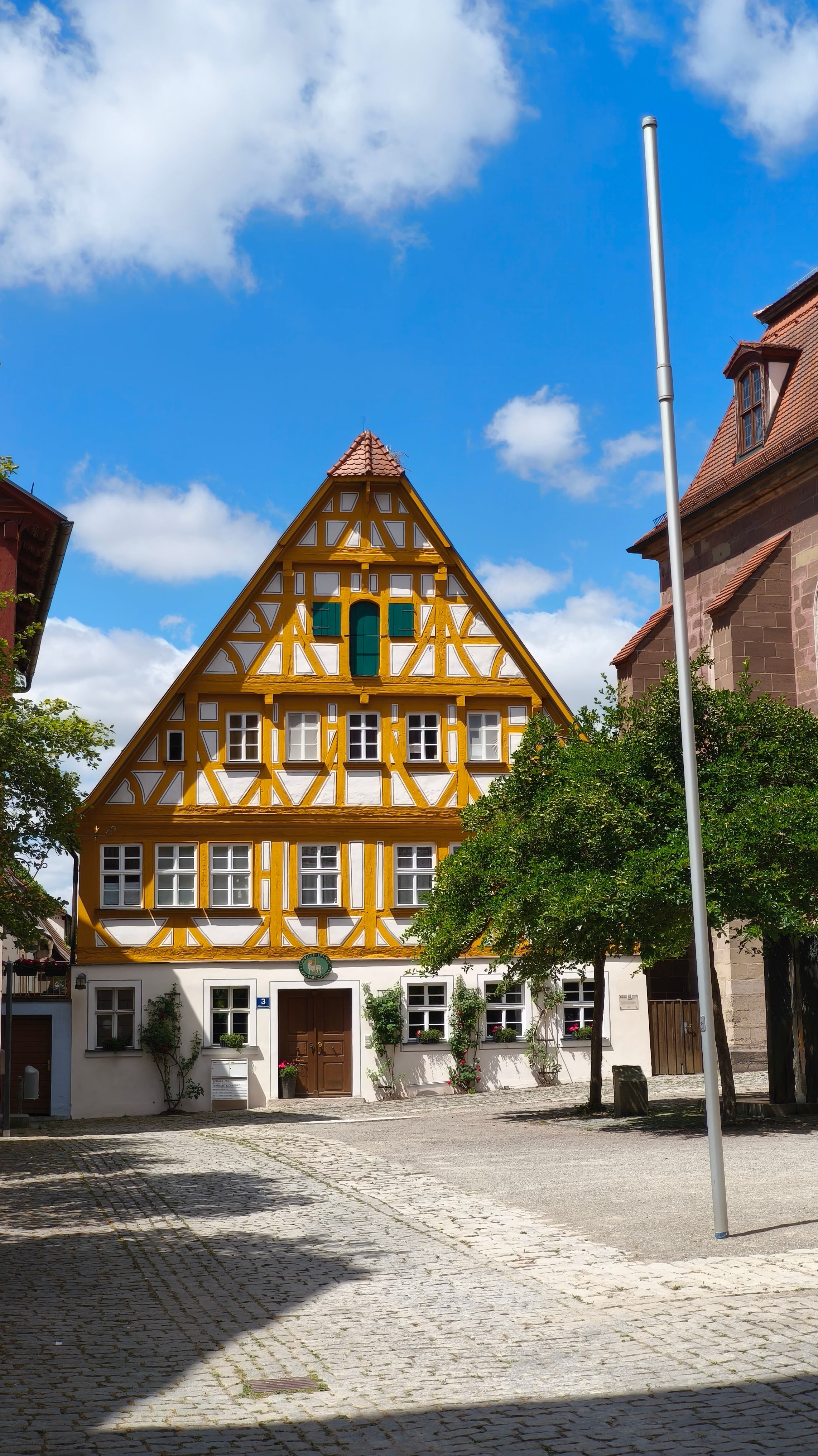 Picturesque half-timbered house in Bad Windsheim, Germany under a sunny sky.