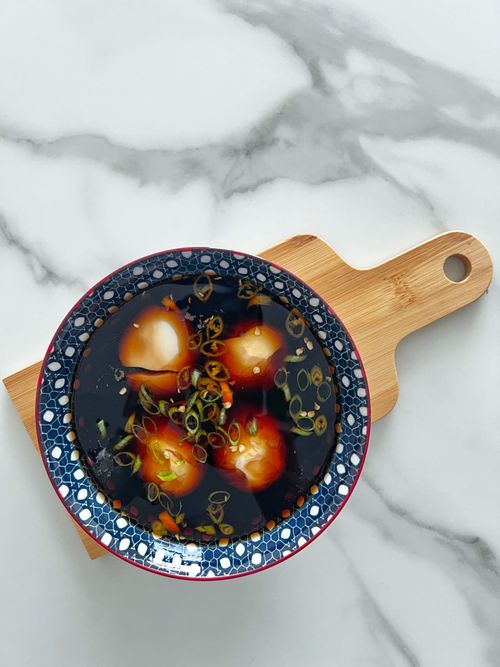 Free Beautifully styled marinated eggs in soy sauce with green onions, served in a Japanese bowl on a wooden board. Stock Photo