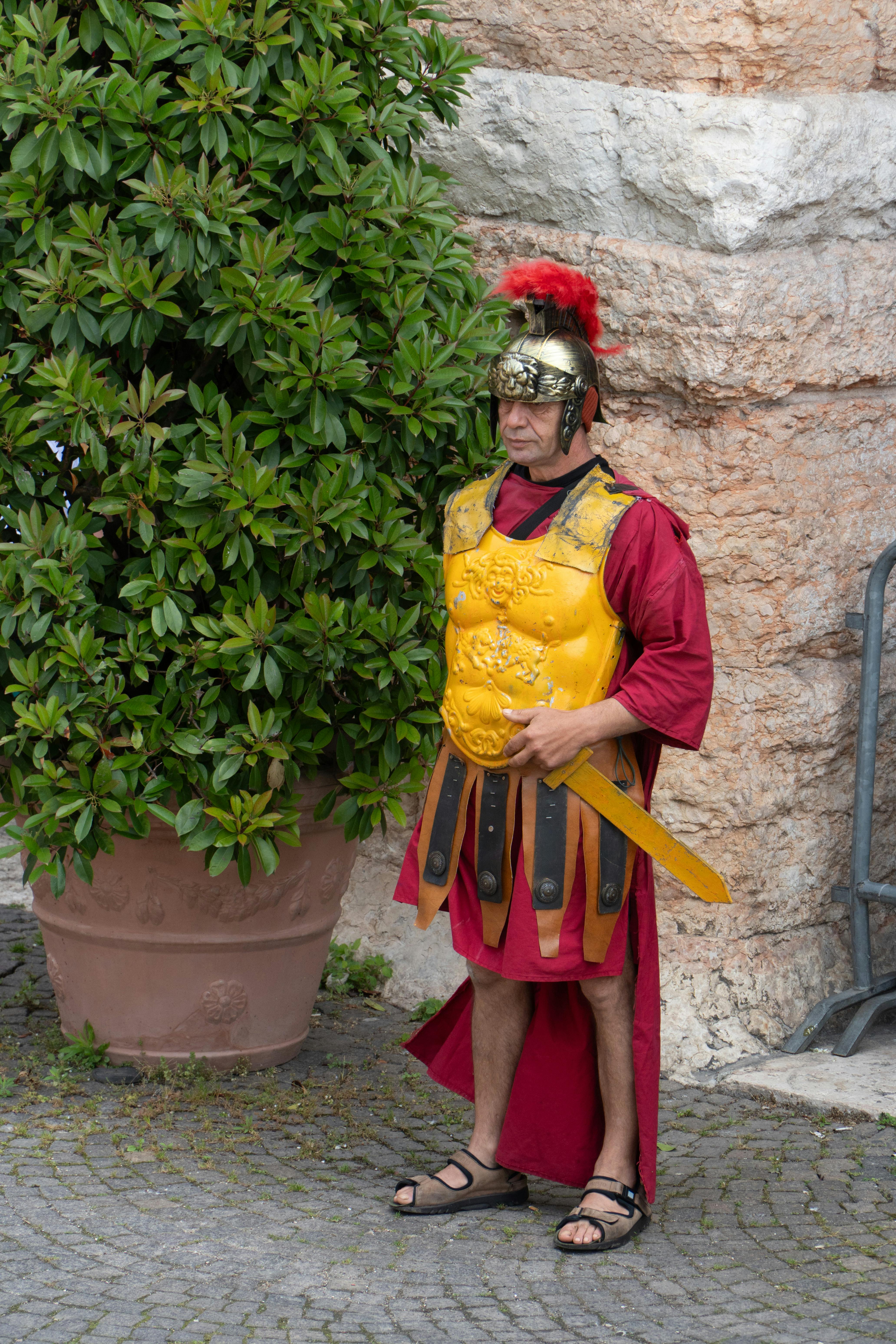Roman legionary reenactor in traditional armor poses in Verona, Italy.
