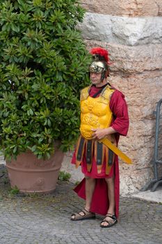 Roman legionary reenactor in traditional armor poses in Verona, Italy.