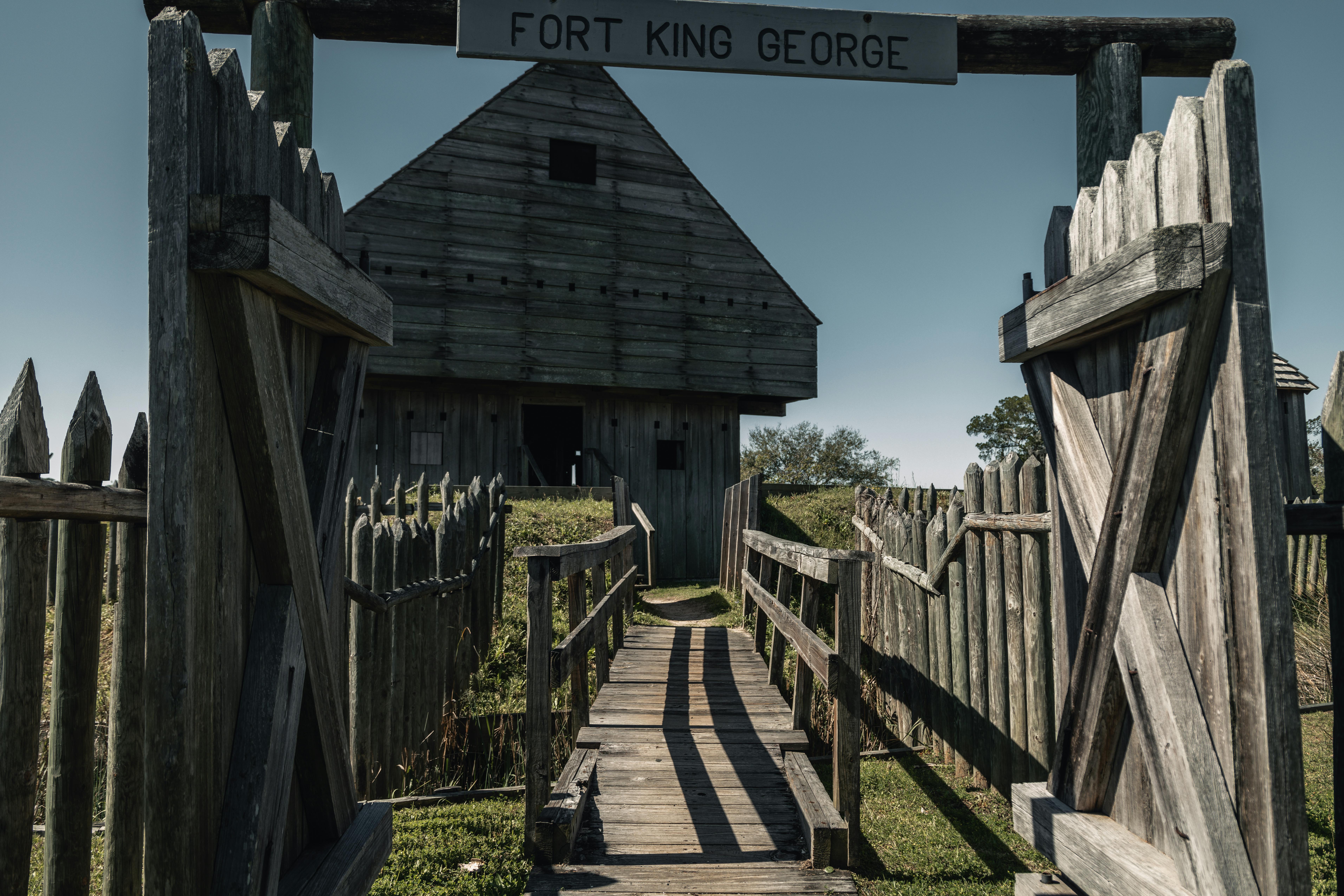 Explore the wooden structure of Fort King George, highlighting its historic architecture under a clear blue sky.