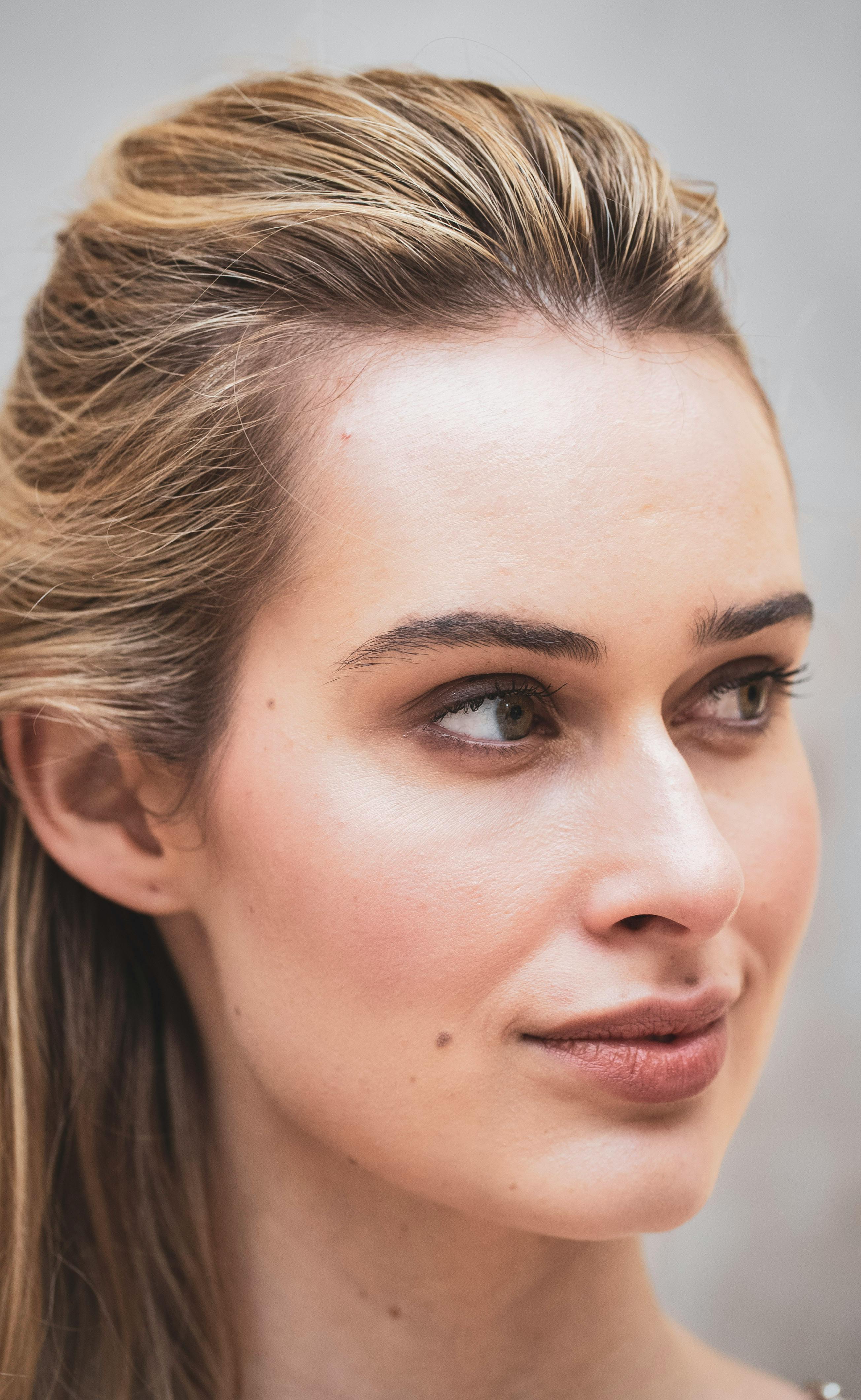 Free Close-up portrait of a young woman with blonde hair and serene expression, captured in Milan, Italy. Stock Photo