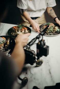 A behind-the-scenes look at a food photoshoot with Japanese dishes being styled and filmed.