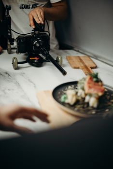 Behind-the-scenes look at an Asian dish being captured with professional video camera lighting setup.
