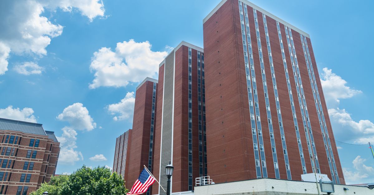 Tall urban buildings with American flag on a sunny day; perfect for architecture and cityscape themes.