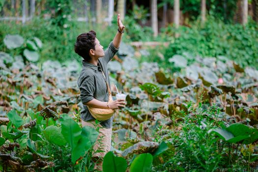 Individual exploring a lush garden with green foliage and vibrant plant life.