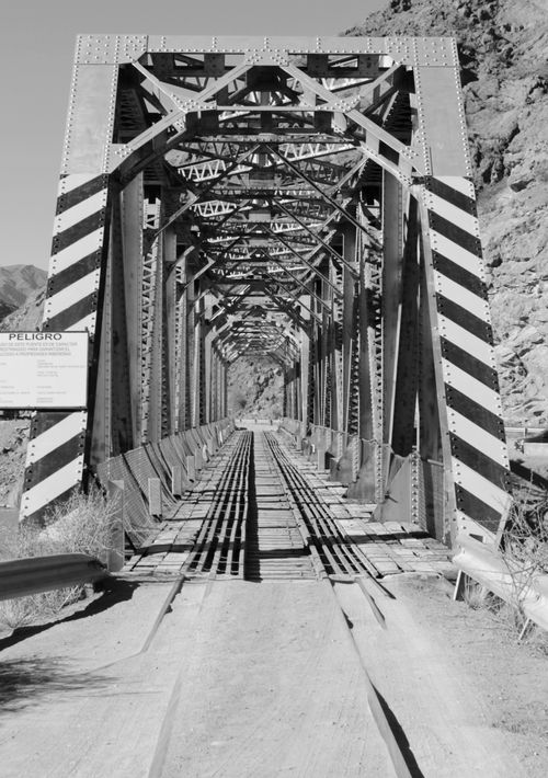 Free Black and white photo of a historic iron bridge in Potrerillos, showcasing engineering and natural beauty. Stock Photo