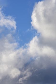 Vivid blue sky with fluffy white clouds in daylight, depicting serenity.