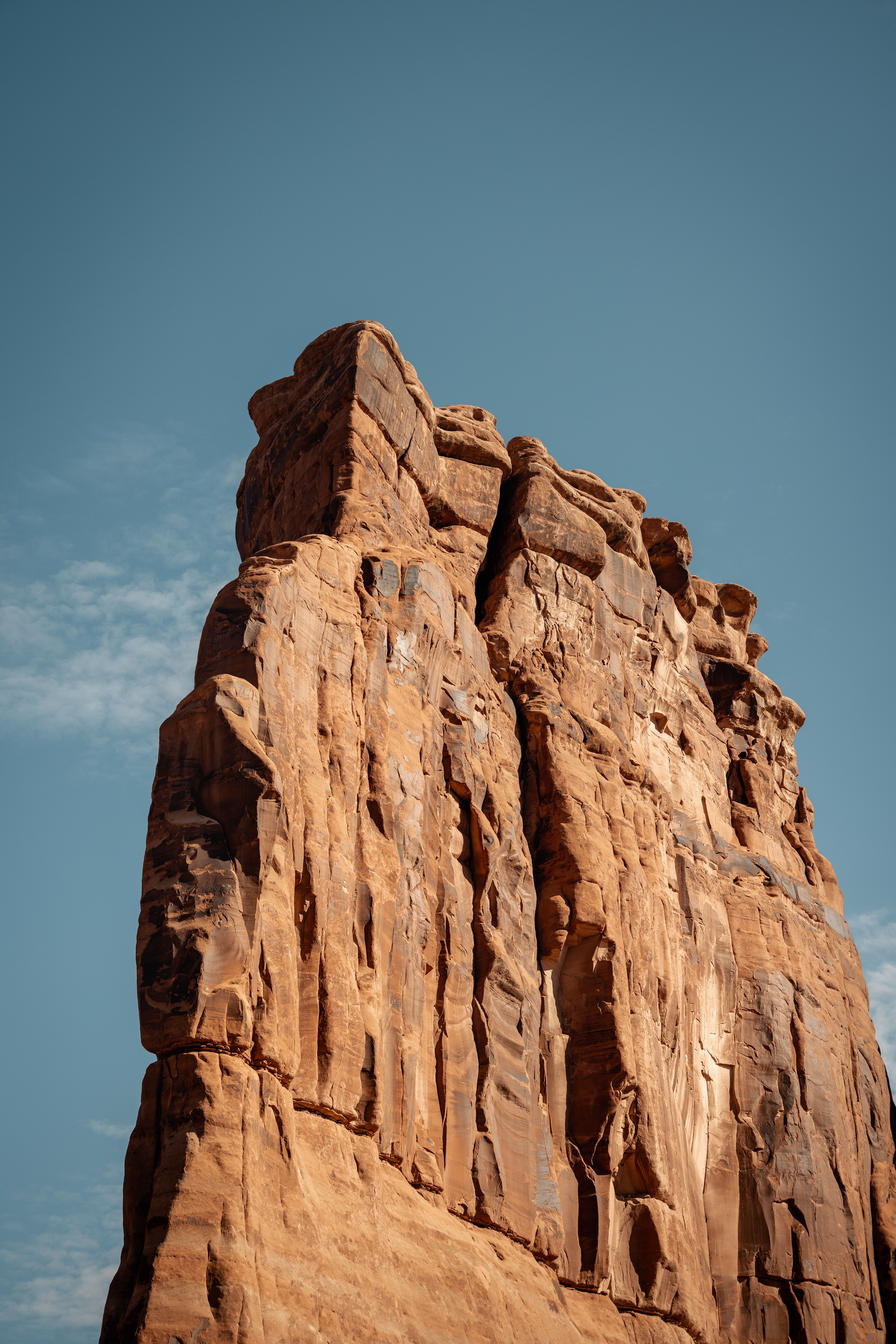 Explore the stunning red rock formation under a clear blue sky in Utah's desert landscape.