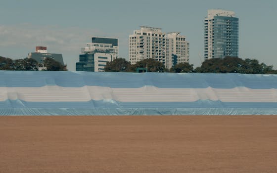 Panoramic view of large Argentinian flag with cityscape of Buenos Aires in the background.