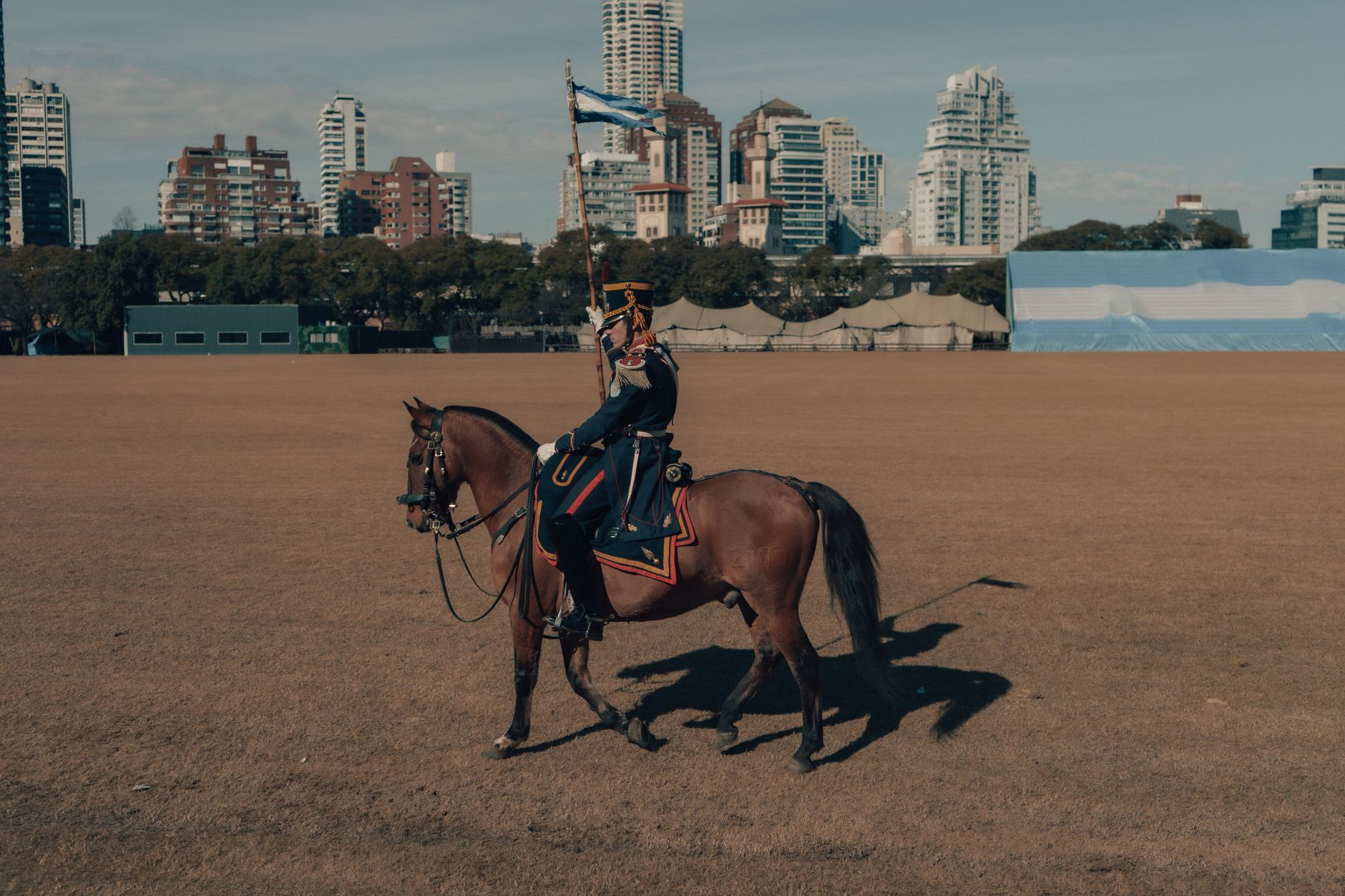 A mounted soldier rides through Buenos Aires, blending tradition with the modern city skyline.