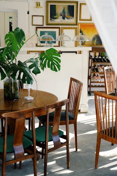 Inviting dining room with wooden table, chairs, and vibrant indoor plants.