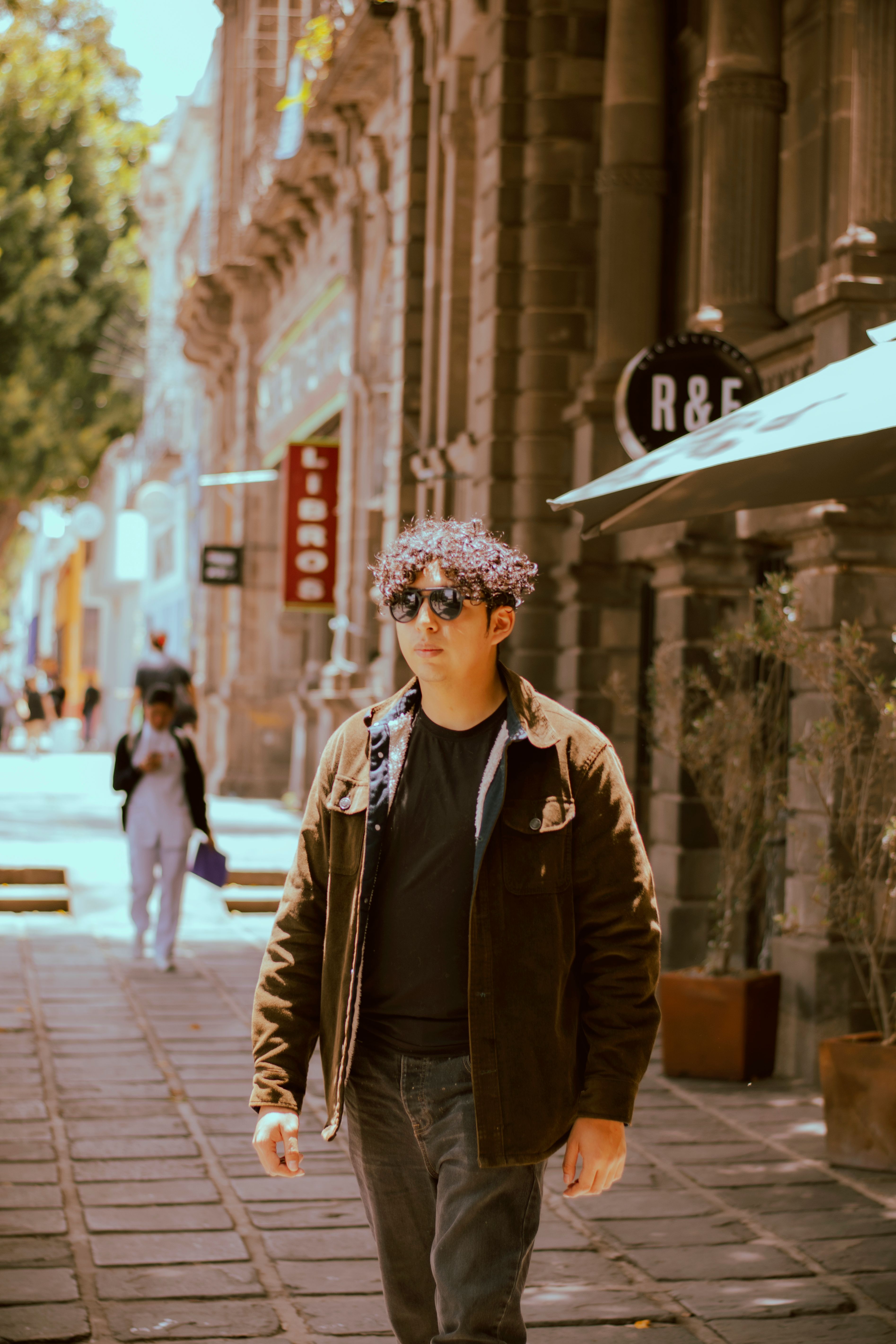 Young man walks along historical street in Puebla de Zaragoza, capturing the essence of the city's culture.