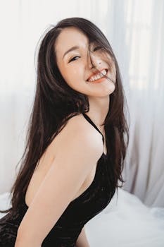 一位身穿黑色连衣裙的女子在室内笑容灿烂，显得十分快乐