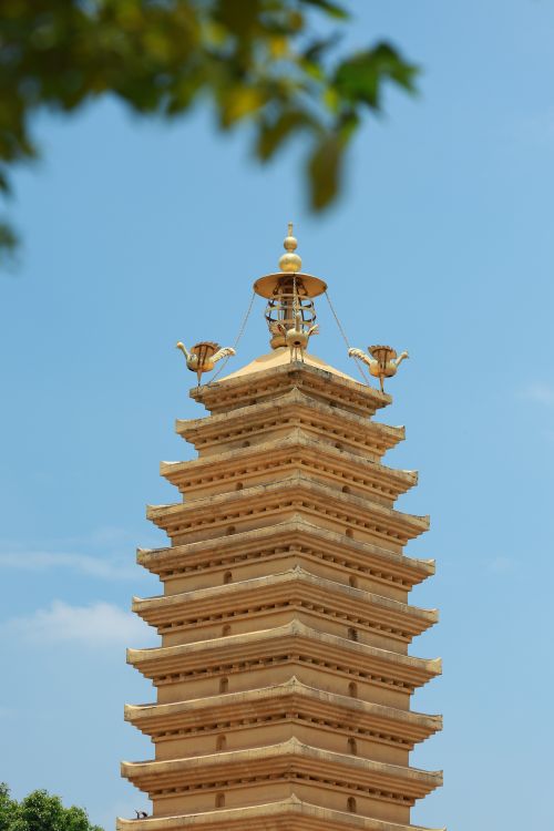 Free A traditional pagoda tower with ornate golden spire under a clear sky. Stock Photo