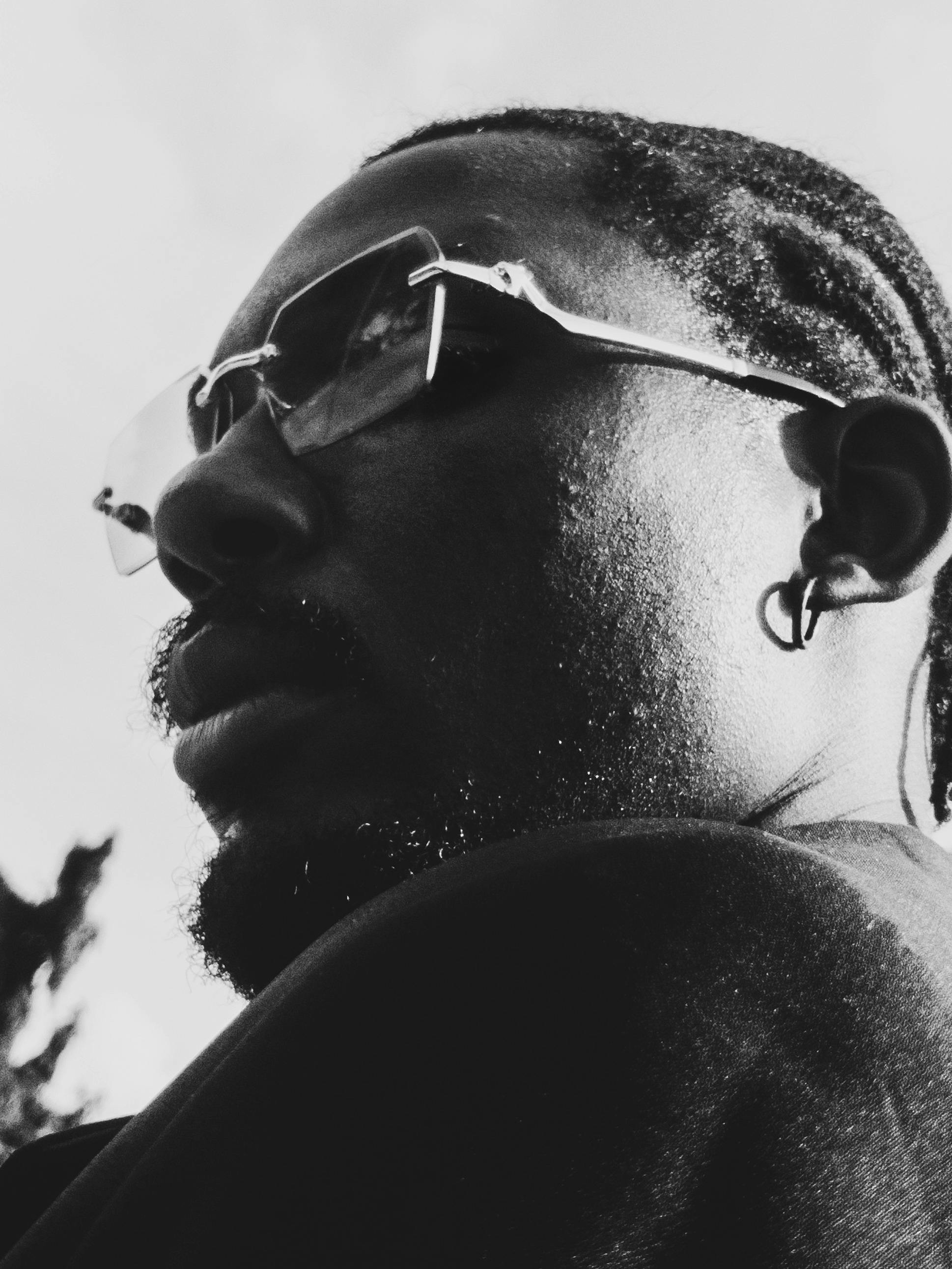 Artistic close-up portrait of a man in glasses shot in black and white.