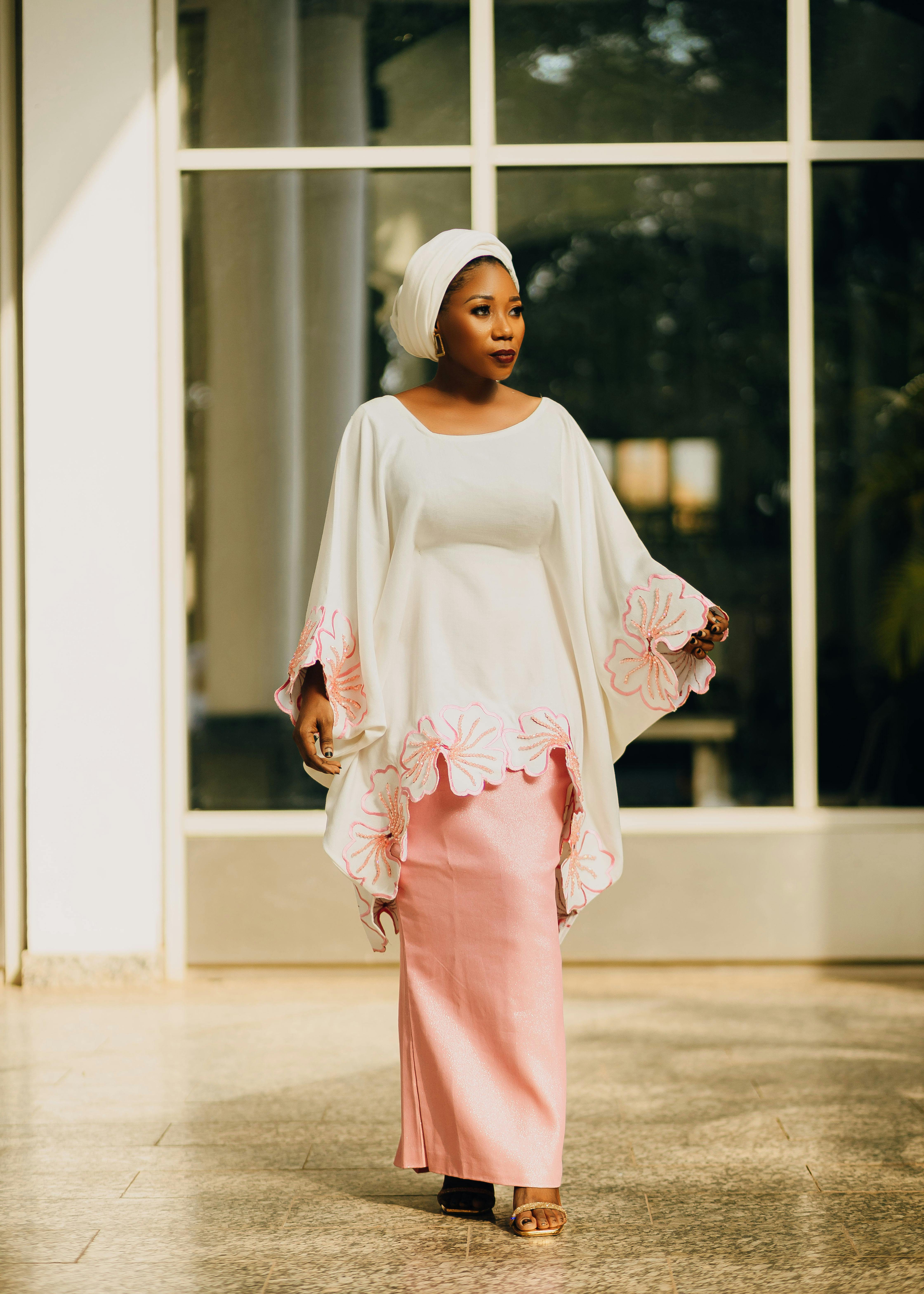 Graceful woman wearing traditional African attire with a serene background indoors.