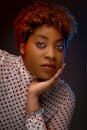 这是一张工作室肖像特写，画面中一位美丽的黑人女性身着圆点图案服饰，妆容优雅，尽显时尚风格