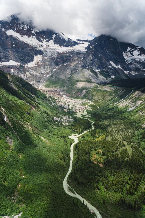 Free Breathtaking aerial view of lush green valley with majestic mountains and winding river. Stock Photo