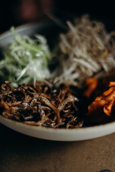 Appetizing close-up of an Asian dish featuring mushrooms, carrots, and fresh vegetables.