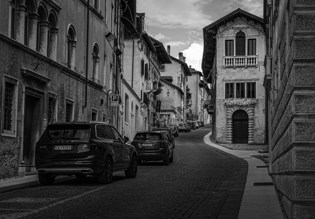A figure walking down an empty cobbled European street