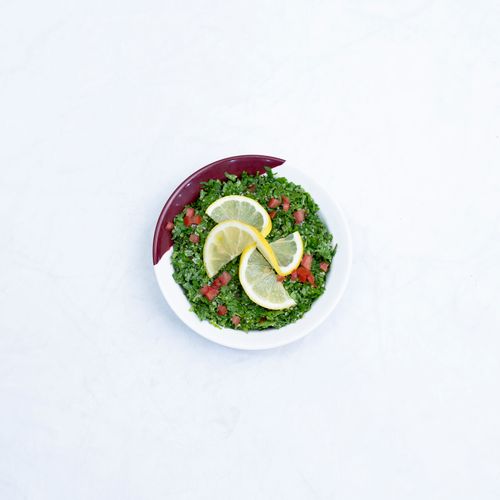 Free Top view of vibrant tabbouleh salad with fresh lemon slices on a white background. Stock Photo