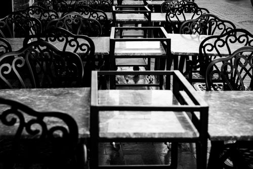 Free Empty outdoor cafe tables and ornate chairs in black and white. Stock Photo