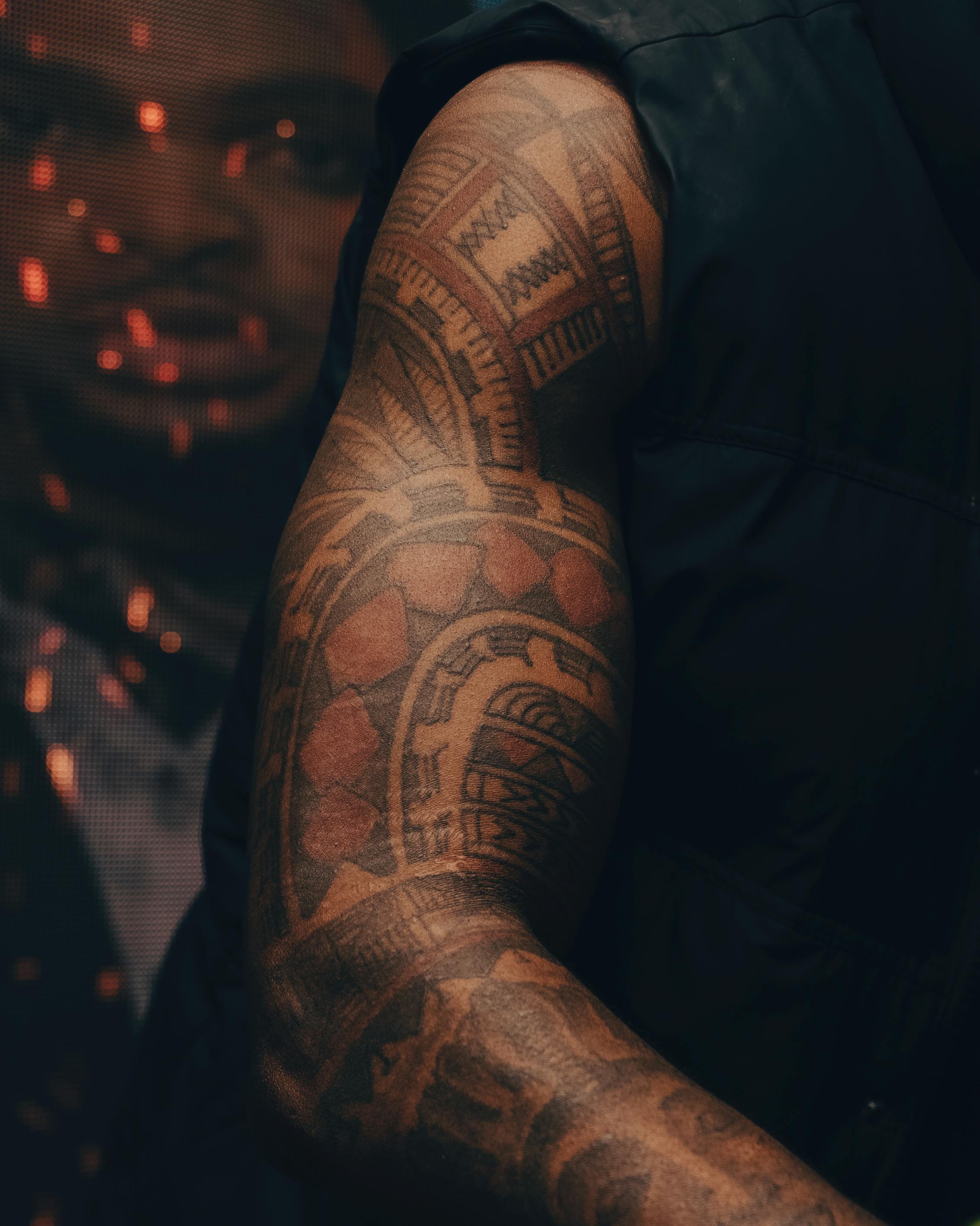 Detailed view of an arm showcasing a complex tribal blackwork tattoo