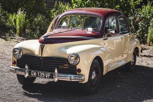 Free Charming vintage car parked in a sunny garden, showcasing classic automotive design. Stock Photo