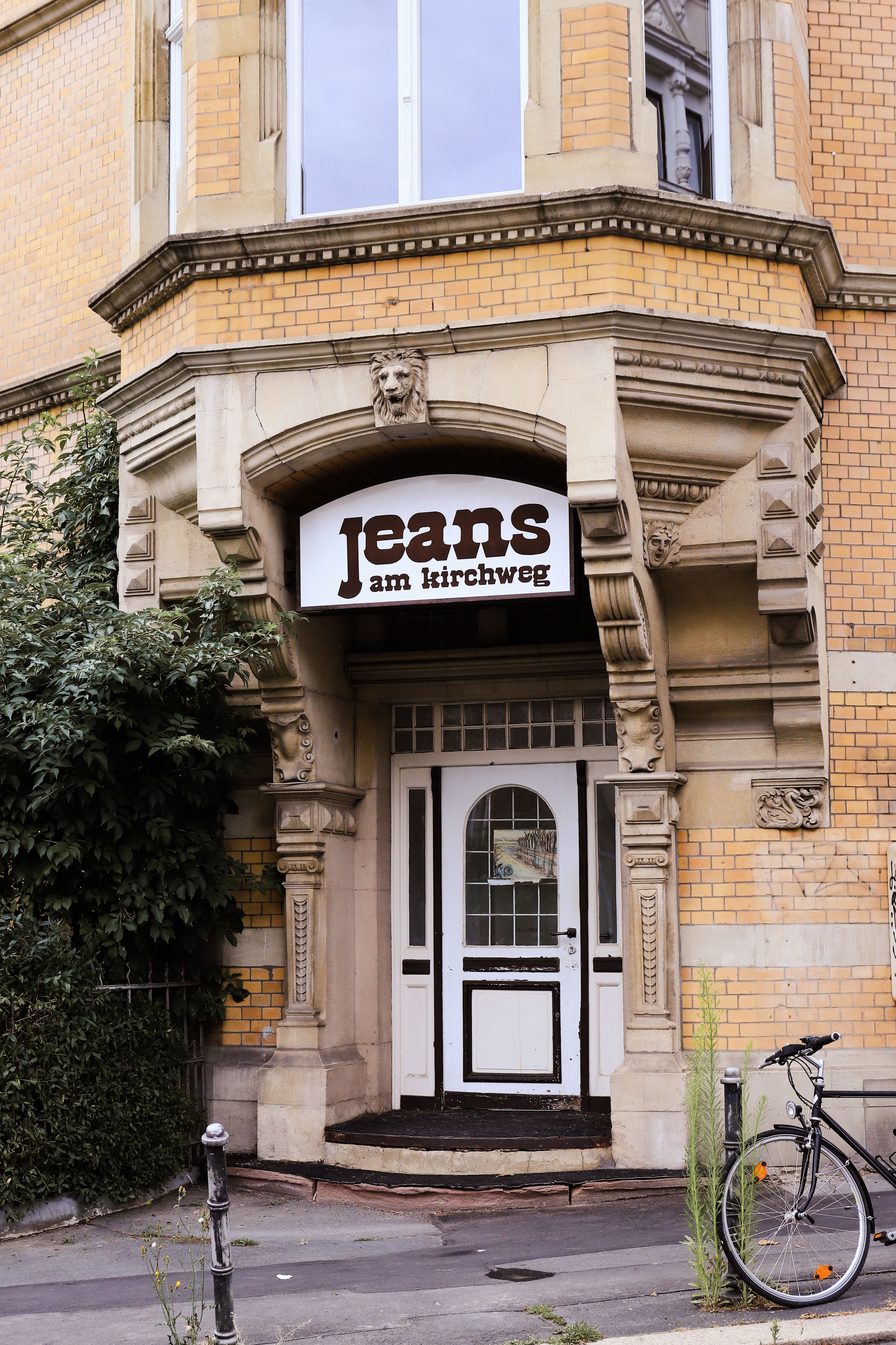 A vintage style jeans shop entrance in Kassel, Germany, showcasing unique architectural details.