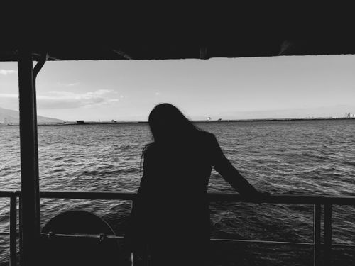 Free Black and white silhouette of a person standing on a ferry overlooking the Aegean Sea in Türkiye. Stock Photo