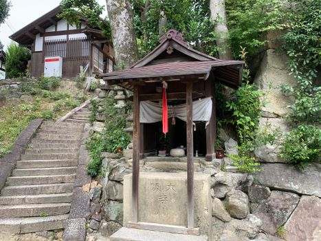 Explore a serene Shinto shrine surrounded by lush greenery and traditional architecture, capturing the essence of Japan.