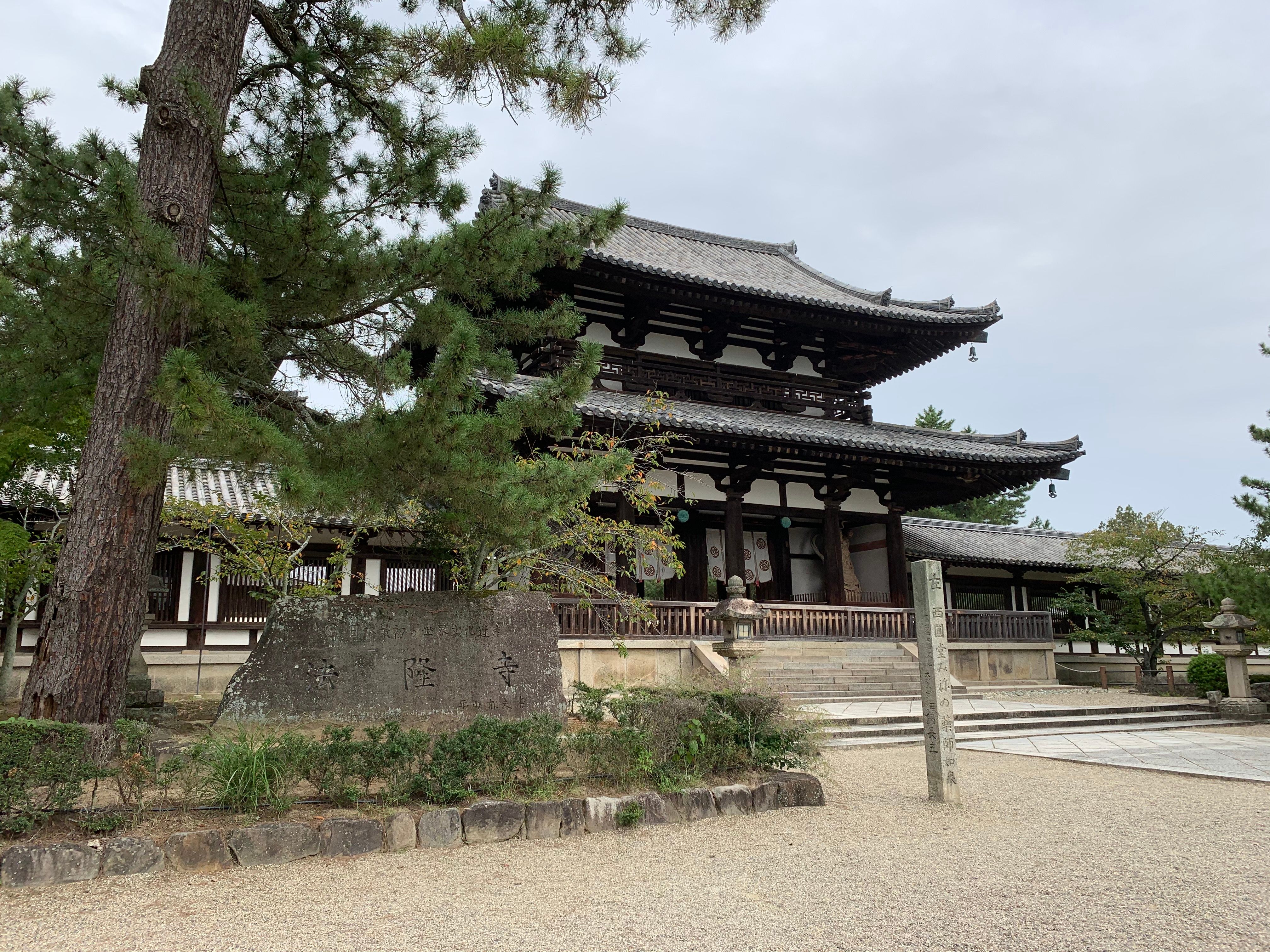 Nanzen-ji Temple bathed in soft morning mist with autumn leaves framing the iconic Sanmon Gate and stone pathways