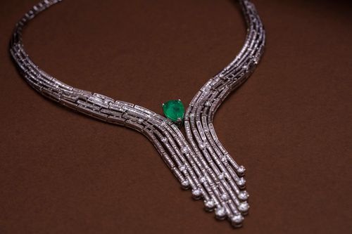 Free Luxurious diamond necklace featuring an exquisite emerald on a brown background. Stock Photo